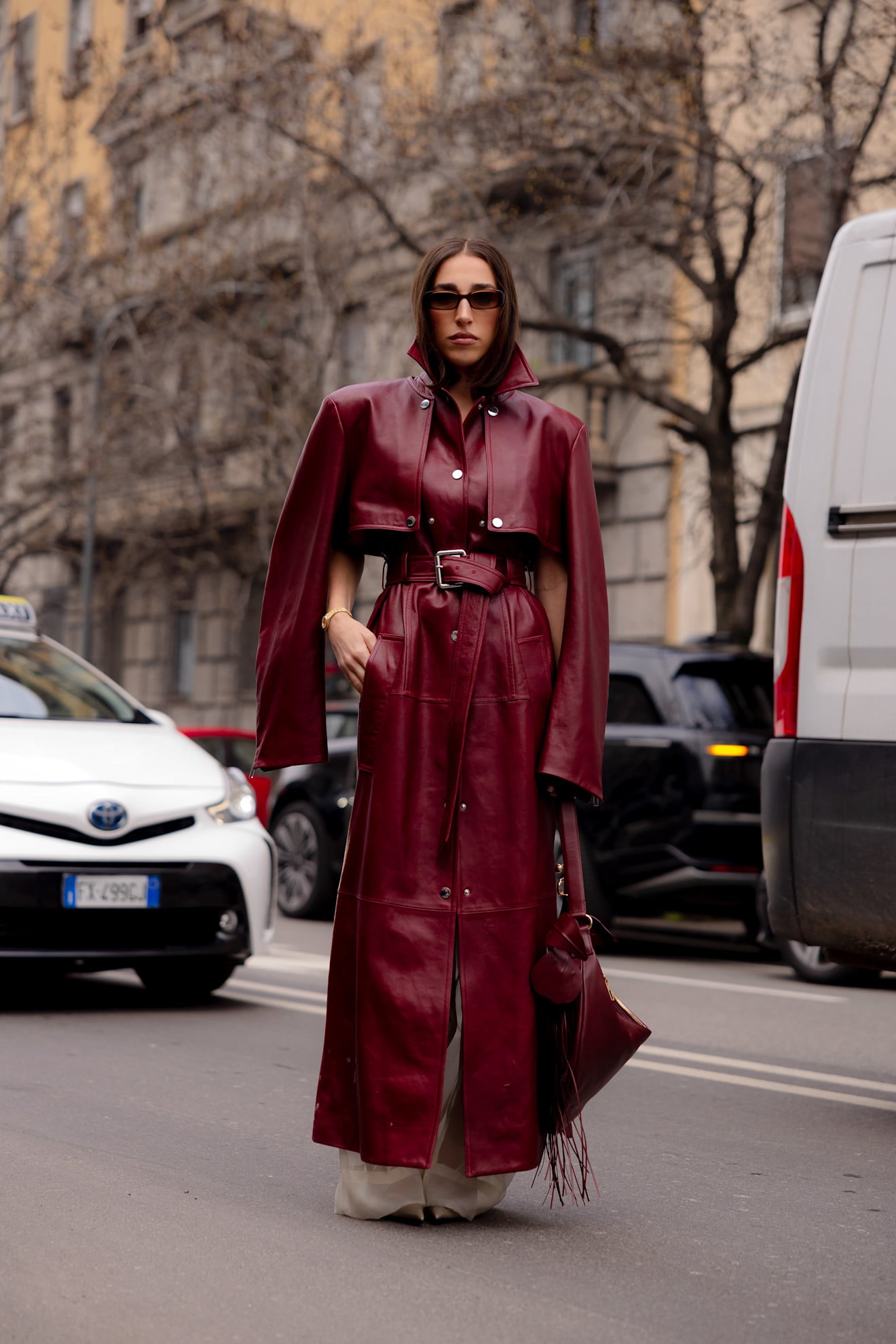 A woman wearing a thick red leather trench coat with a modular build
